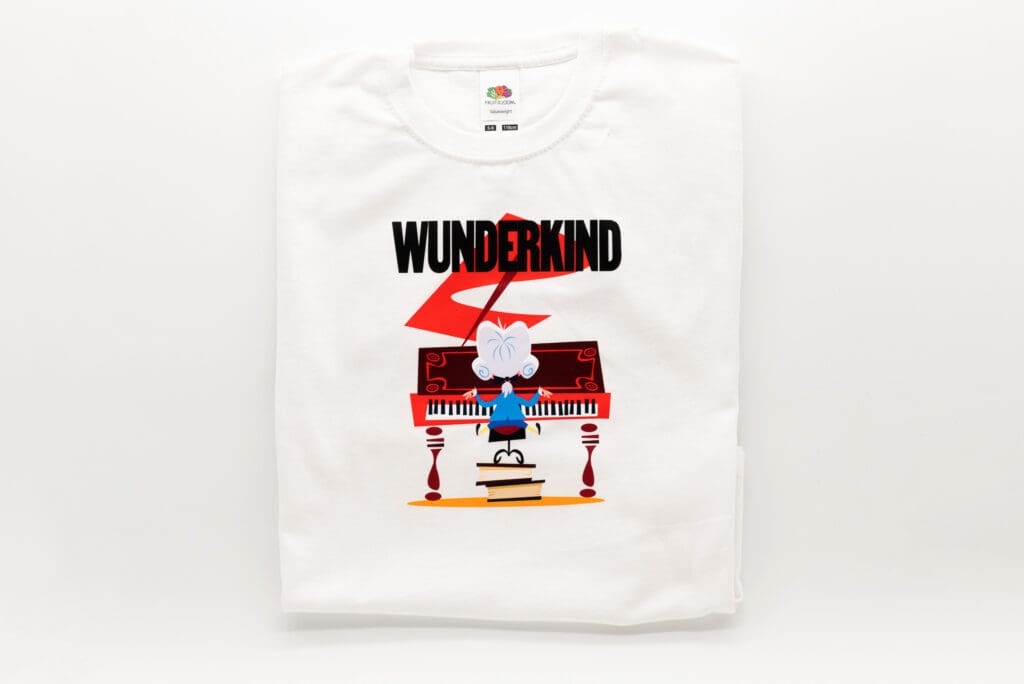 Weißes Kinder T-Shirt mit farbigem Aufdruck eines kleinen Musikers am roten Klavier und dem schwarzen Schriftzug WUNDERKIND darüber.